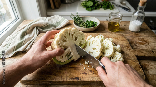 Fresh Cauliflower Being Sliced On A Wooden Cutting Board