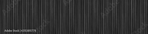 Panoramic black ceramic finger tile wall with slim vertical mosaic strip formatting.