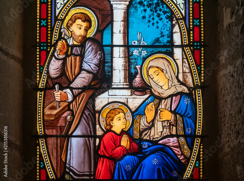 Canvas Print Stained glass (19th century) of Holy family: Jesus infant, Virgin Mary and St Joseph in the workshop of Joseph the carpenter