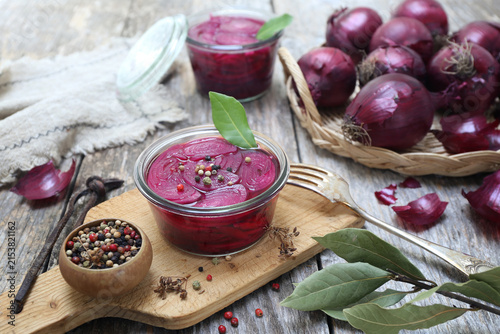 Pickled red onion salad in jar, spices and bay leaf