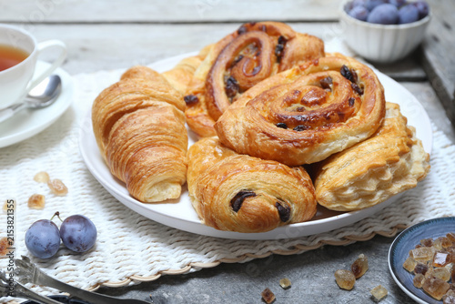French pastry: puff pastry raisin buns and croissants and cup of tea