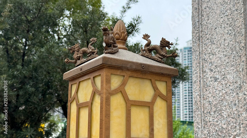 stone lantern with dragon statues in serene outdoor setting, close-up of top, gray and brown tones, traditional architecture, cultural heritage, landmarks, possibly in park or garden.