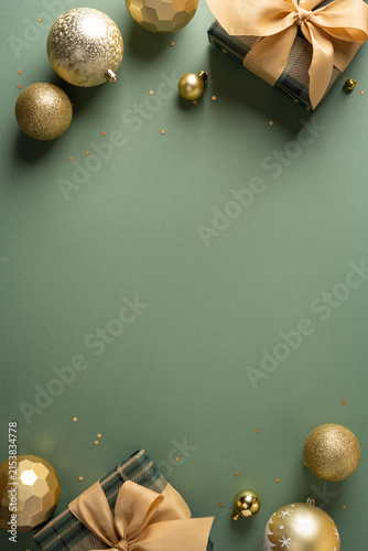 Golden Christmas ornaments and wrapped gifts on sage vertical green background for Merry Christmas and Happy New Year