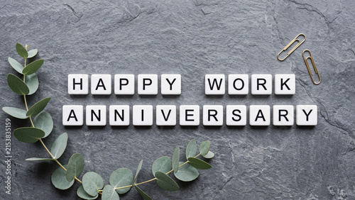 Happy work anniversary letter tiles with eucalyptus on grey slate stone