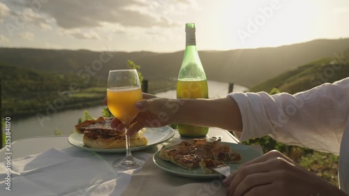Young Woman Enjoys Federweisser young wine served with Onion tart Zwiebelkuchen. Rhine Valley terraced vineyards Germany