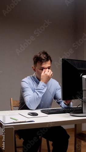 Bild auf Leinwand Man experiencing fatigue and eye strain from prolonged computer work, feeling st