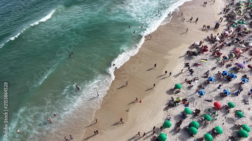 Rio de Janeiro, Brazil, aerial view of Copacabana Beach showing colourful umbrellas and people bathing in the ocean on a summer day. Tropical travel and vacation concept.