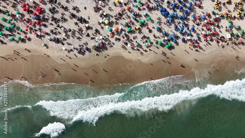 Rio de Janeiro, Brazil, aerial view of Copacabana Beach showing colourful umbrellas and people bathing in the ocean on a summer day. Tropical travel and vacation concept.