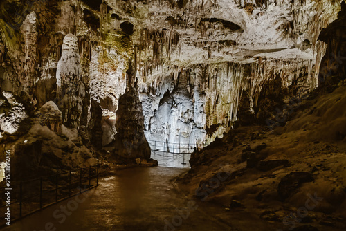 Cuadro en lienzo View of the illuminated limestone formations and stalactites inside the Postojna Cave with a walking path and metal railings in Postojna, Postojna, Slovenia