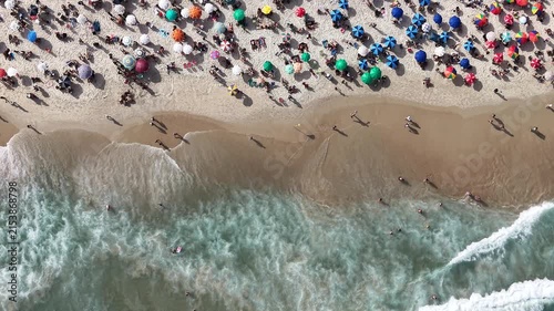 Rio de Janeiro, Brazil, aerial view of Copacabana Beach showing colourful umbrellas and people bathing in the ocean on a summer day. Tropical travel and vacation concept.
