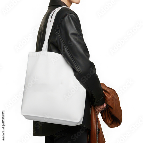 Person carrying white tote bag on shoulder