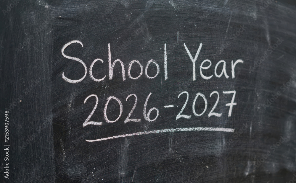 Fototapeta premium School Year 2026 2027 written in chalk on a dark blackboard background educational concept for upcoming academic terms and student planning
