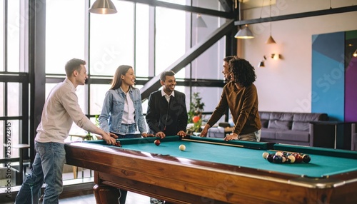 Diverse Group of Young Professionals Playing Billiards in Modern Office Recreation Room