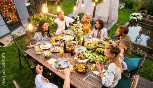 Diverse Group of Friends Enjoying Outdoor Dinner Party at Sunset in Backyard Garden