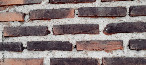 A rustic brick wall with a weathered look and a thick mortar texture.