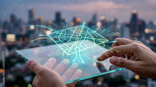 Hand touching a transparent digital tablet screen displaying a floating green energy grid map, glowing smart grid connection lines across a city layout, and electrical circuit patterns.