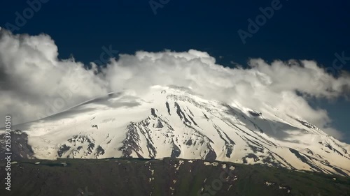Mount Kilimanjaro Tanzania snowy summit rises through swirling clouds and alpine sky.