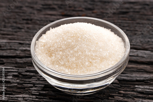 Foto Crystals of refined white sugar in a glass bowl, close-up food photography with detailed texture and a rustic background