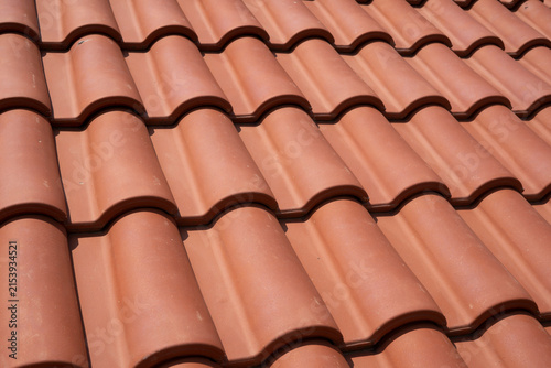 New terracotta clay roof tiles closeup texture pattern background on residential building