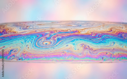 Abstract soap bubble surface macro photography showing vibrant iridescent rainbow colors and swirling liquid patterns for artistic backgrounds and science concepts