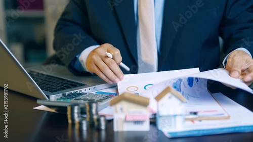 Businessman reviewing and flipping financial report pages to verify accuracy for a client presentation.