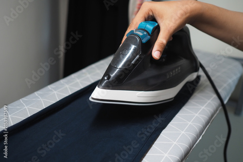 Fotografie Ironing clothes on an ironing board in a room