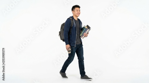 Happy asian college student walking with a backpack and holding books isolated on white background