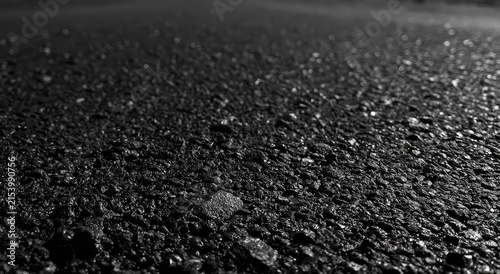 Close-up textured asphalt surface, gritty and dark, with a shallow depth of field