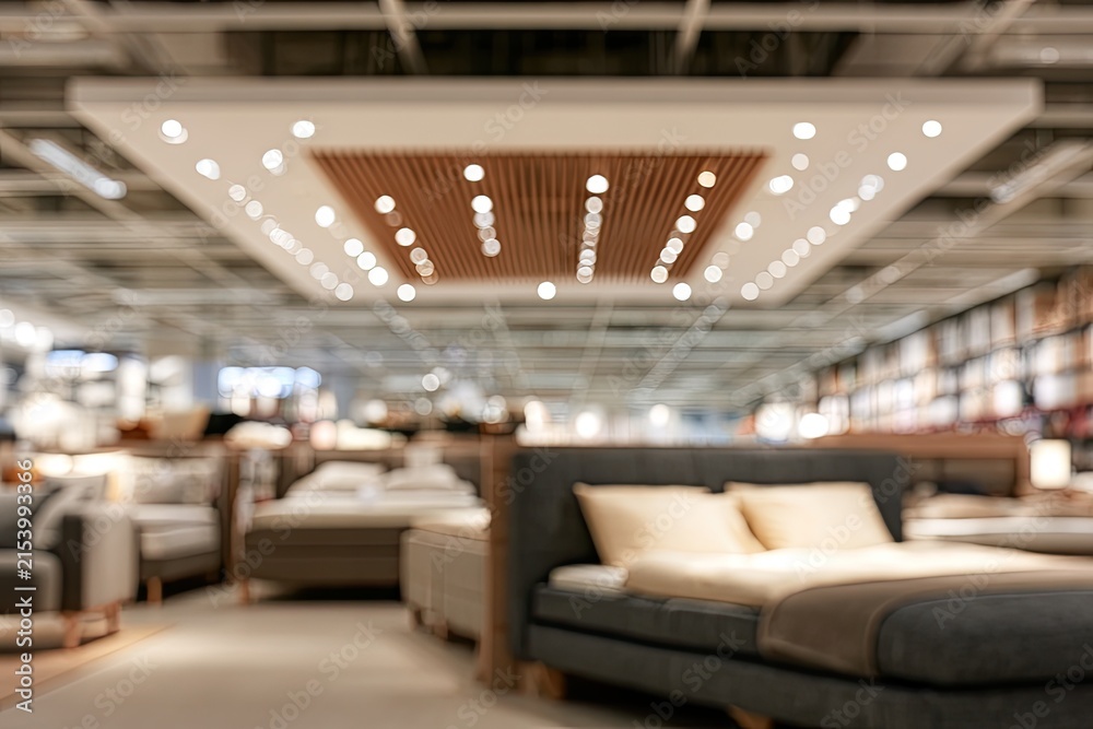Fototapeta premium Blurred interior of a large furniture store, focusing on beds and sofas