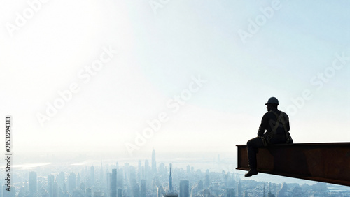 Silhouetted Steelworker Sitting On High Beam Above Hazy Cityscape