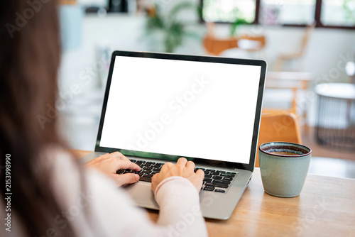 Work from home, online business, and remote working concept: Woman typing on laptop with empty screen mockup for website design