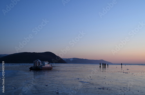 Tourists greet the winter dawn on Lake Baikal. Olkhon Gate Strait