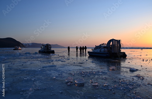 Tourists greet the winter dawn on Lake Baikal. Olkhon Gate Strait