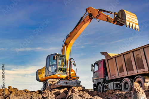 Excavator Loading Dump Truck with Soil at Construction Site