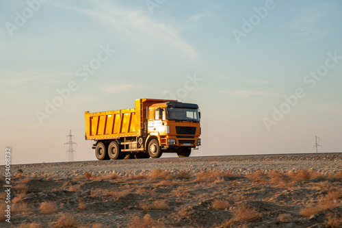 Orange Dump Truck Transporting Materials at Construction Site