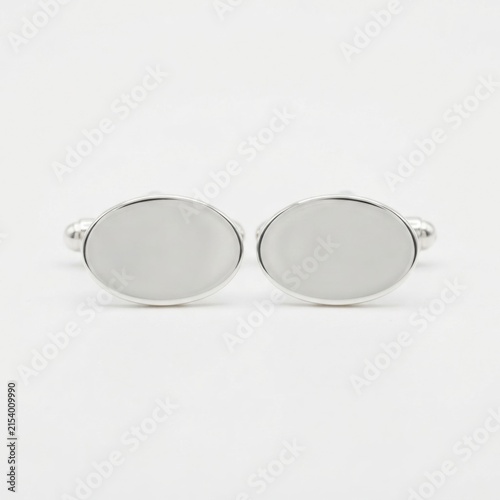 Pair of oval silver cufflinks on white background