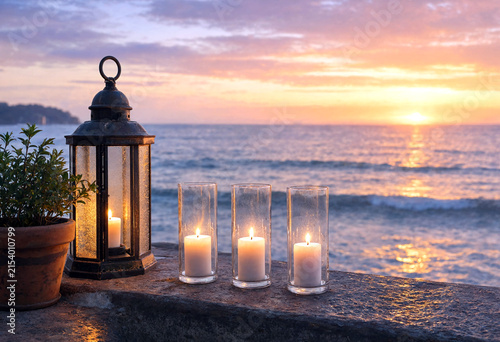 Beautiful sunset over the ocean with lit candles and lantern creating a peaceful ambiance