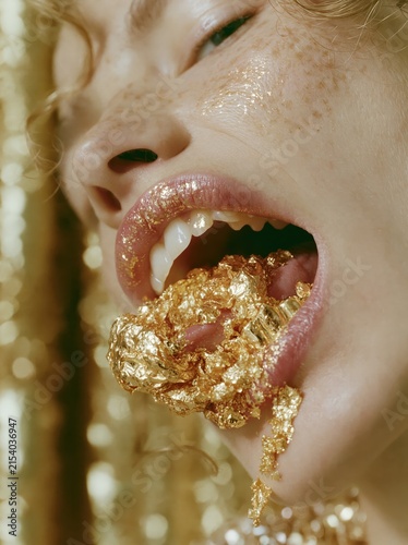 Close up of a woman's mouth with gold leaf and glitter on lips and face