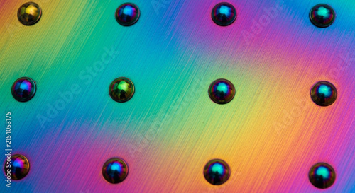 Iridescent metal spheres on a vibrant holographic rainbow background texture