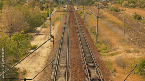 Cuadro en lienzo Parallel railway tracks recede into horizon under warm sunlight