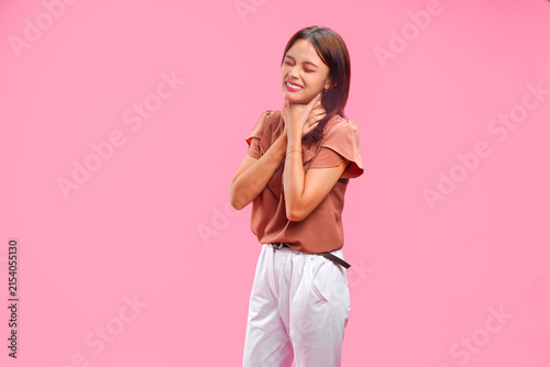 Fotografie Young Asian woman in a brown shirt is holding her neck feeling unwell and coughing