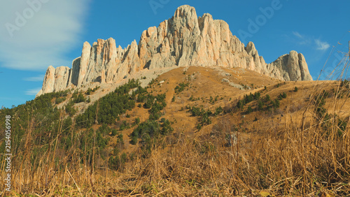 Canvastavla Dramatic mountain landscape with jagged rock formations bathed in warm sunlight