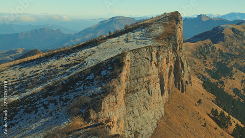 Foto Dramatic aerial view of rugged mountain ridge with snow patches exposed rock face