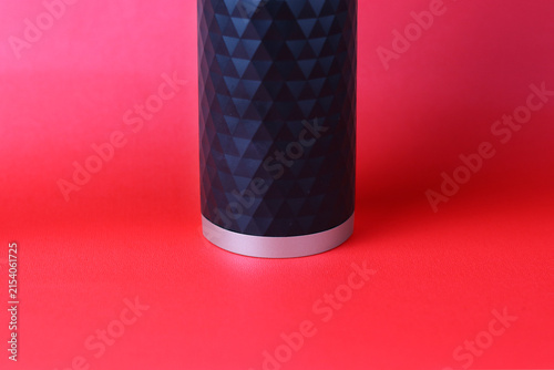 Close-up of a sleek black cylindrical object with a geometric textured surface