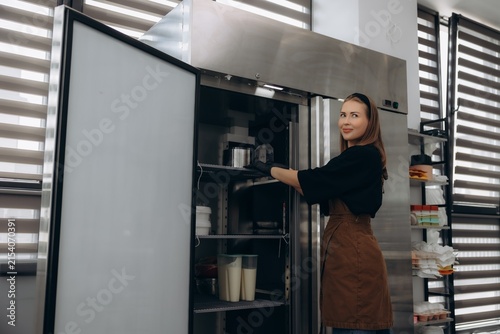 Foto Pastry chef arranging food in commercial refrigerator