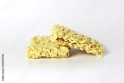 Uncooked instant noodles stacked on a clean white background
