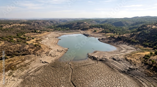 Aerial view of a dried up reservoir showing cracked earth and low water levels due to drought.