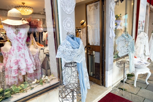 Traditional Burano lace shawls and handmade textiles displayed in a boutique shop window, Venice, Italy