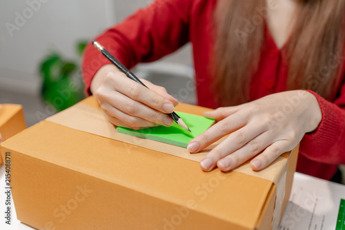 Small business owner packing customer orders with bubble wrap, sealing shipping boxes and preparing parcels for delivery in an ecommerce warehouse. Online retail fulfillment and logistics workflow.