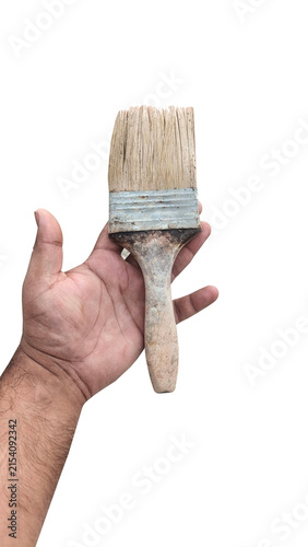 A hand holds a used paint brush ready for home renovation or art project isolated on white background with soft studio lighting